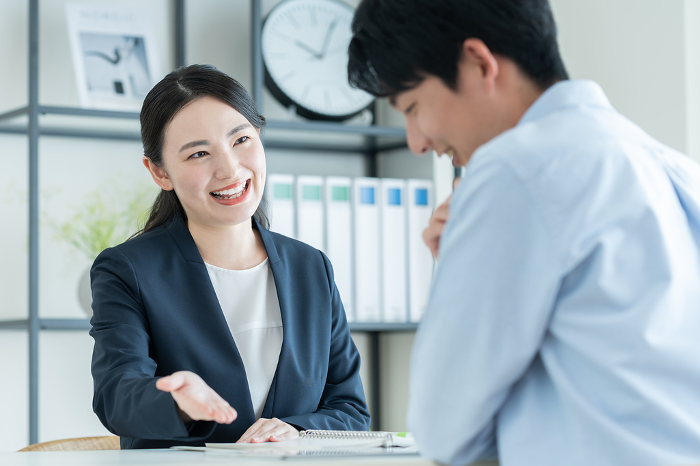 Japanese businesswoman selling to a young man (Female / People)