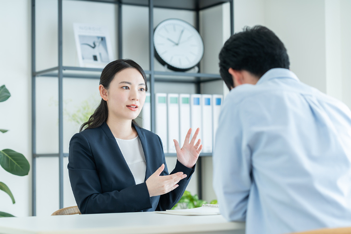 Japanese businesswoman consulting with a young man (Female / People)