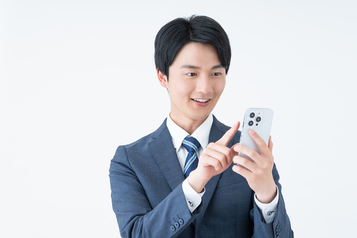 Young Japanese businessman looking at his phone (People)