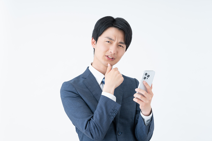 Young Japanese businessman troubled by his phone (People)