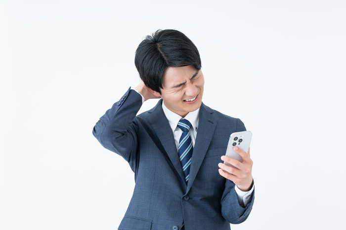 Japanese businessman troubled by his cell phone.