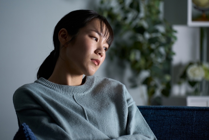 Japanese woman thinking in a dark room.