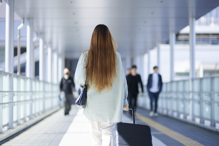 Female inbound international travelers moving with suitcases