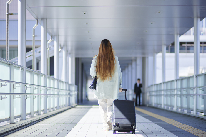 Female inbound international travelers moving with suitcases
