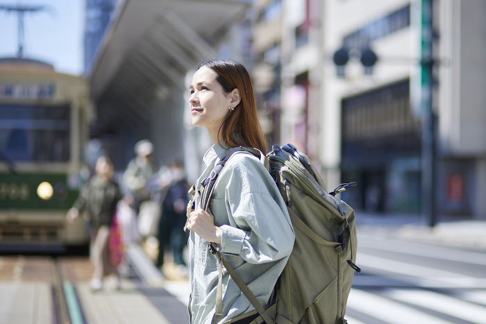 Female inbound backpacker walking with backpack on her back