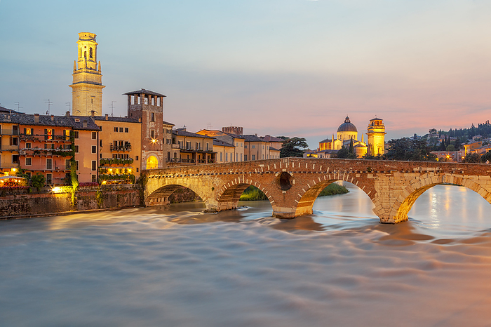 Veneto, Italy Ponte Pietra at dusk, with the bell tower of Verona Cathedral on the left and San Giorgio in Braida on the right. Verona, Veneto, Italy.