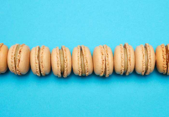 Chocolate macarons on a blue background, dessert. Top view Chocolate macarons on a blue background, dessert. Top view