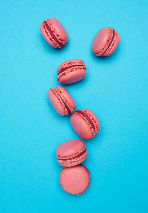 Pink macarons on blue background, top view Pink macarons on blue background, top view