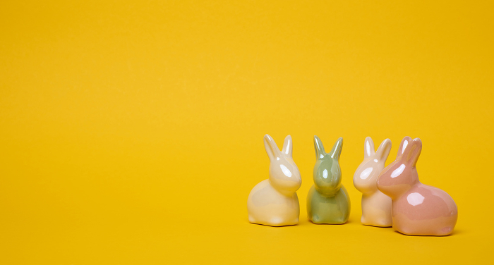Ceramic decorative bunnies on a yellow background, festive Easter background. Copy space Ceramic decorative bunnies on a yellow background, festive Easter background. Copy space