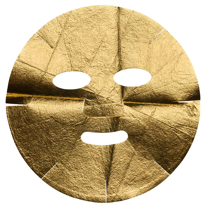 Fabric golden cosmetic face mask with cut holes on isolated background Fabric golden cosmetic face mask with cut holes on isolated background