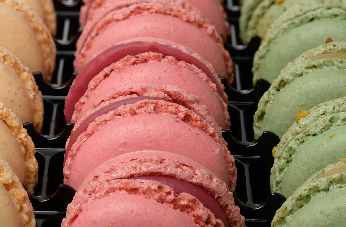 Raspberry and pistachio macarons in a plastic box, dessert. Close up Raspberry and pistachio macarons in a plastic box, dessert. Close up