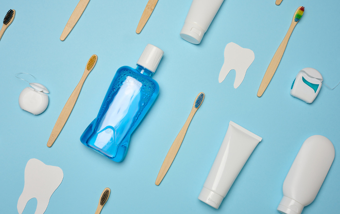 Mouthwash, toothpaste tube, dental floss on a blue background, oral hygiene.  Top view Mouthwash, toothpaste tube, dental floss on a blue background, oral hygiene.  Top view