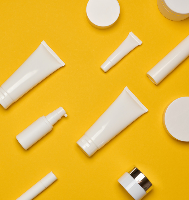Various types of white plastic packaging, bottle, jar, tube on a yellow background. Container for cosmetics Various types of white plastic packaging, bottle, jar, tube on a yellow background. Container for cosmetics