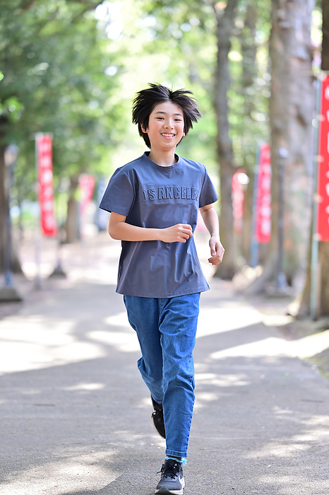 A boy running along the approach to a shrine