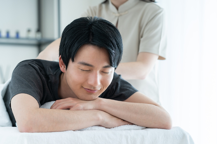 Young Japanese man receiving a massage (People)