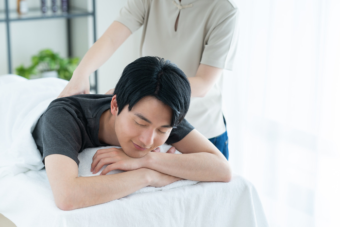 Young Japanese man receiving a massage (People)