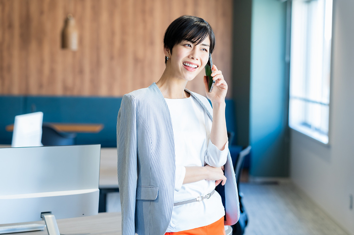 Japanese businesswoman on the phone in office (Female / People)