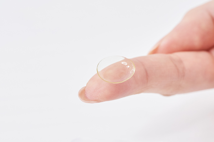 Woman's fingers with contact lenses