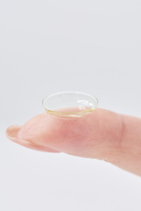 Woman's fingers with contact lenses