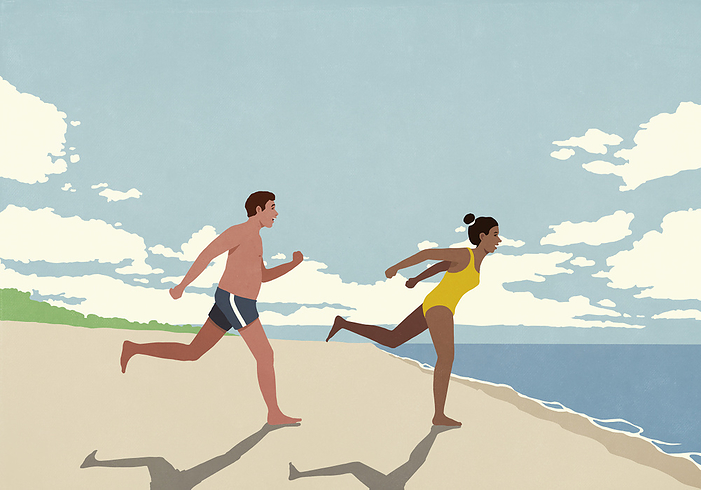 Happy, excited couple running toward ocean on sunny summer beach