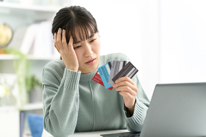 A Japanese woman having trouble choosing a credit card (People)