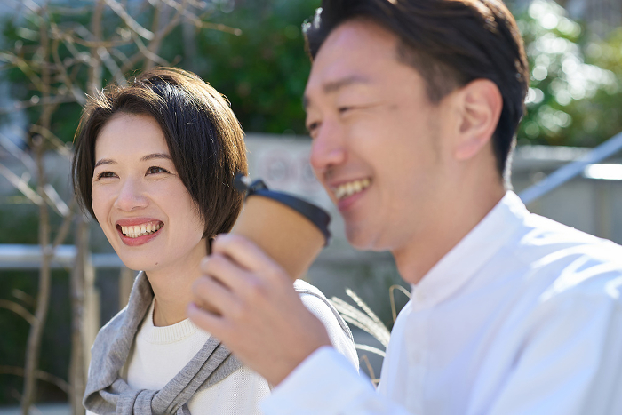 Japanese man and woman talking intimately outdoors (People)