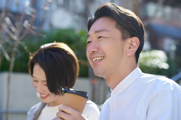 Japanese man and woman talking intimately outdoors (People)