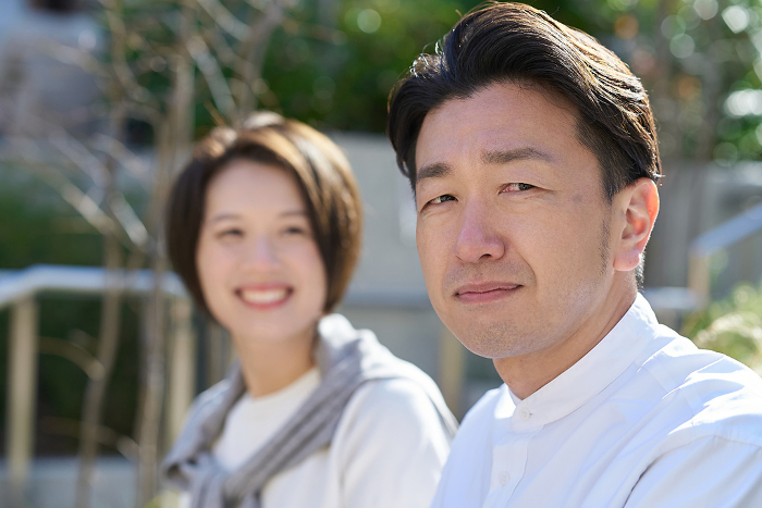 Japanese man with a sour expression next to a woman (People)
