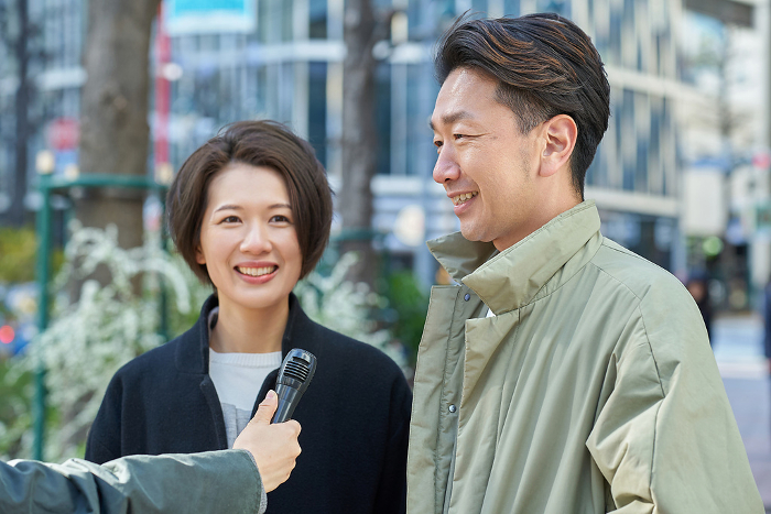Japanese man and woman being interviewed on the street (People)