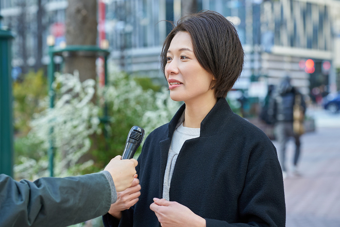 Japanese woman being interviewed on the street (People)
