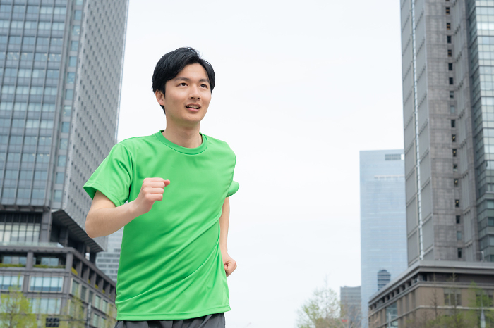 Young Japanese man running in an office area (People)