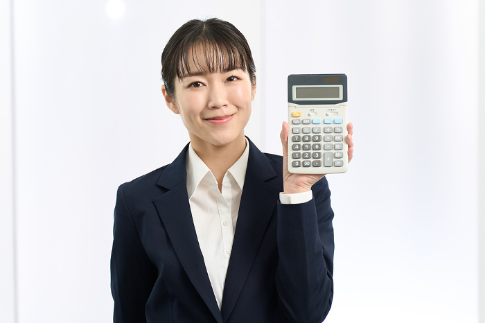 Japanese businesswoman holding a calculator with a smile (Female / People)