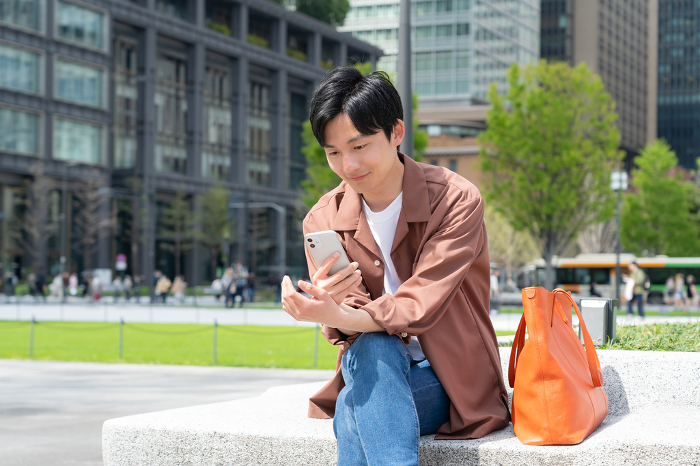 Young Japanese man looking at his phone (People)
