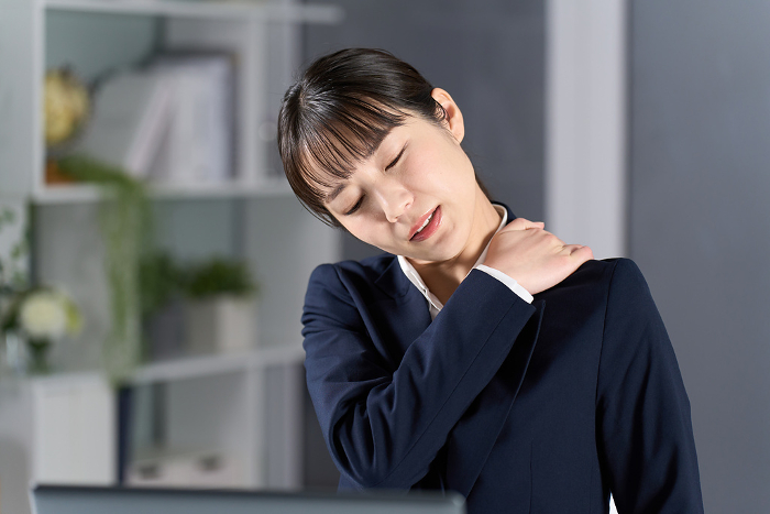 Japanese businesswoman with stiff shoulders due to overtime work （Female / People)