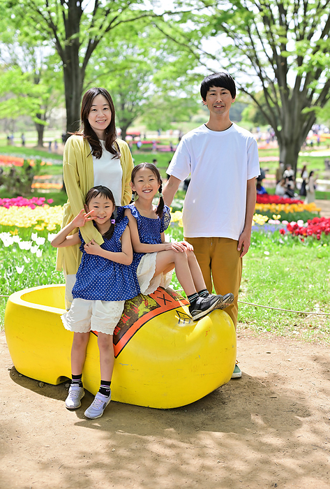A family poses for a photo in a park