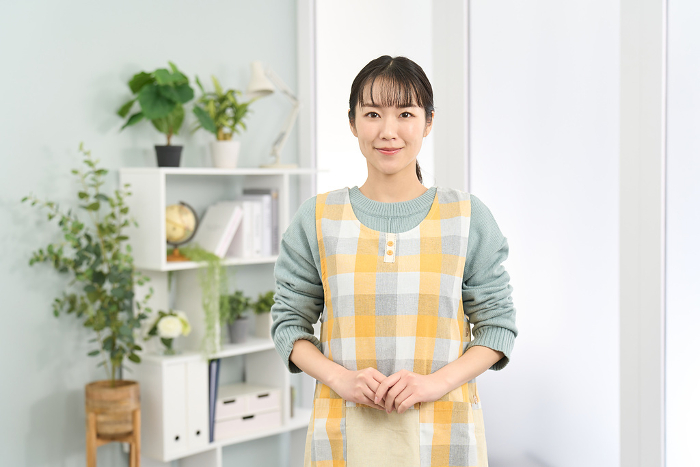 Japanese woman in apron standing smiling (People)