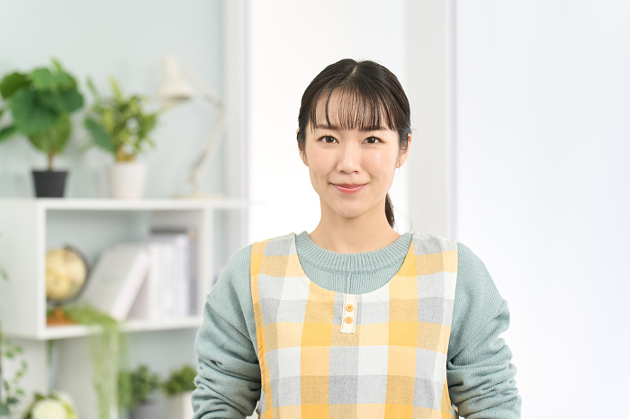 Japanese woman in apron standing smiling (People)