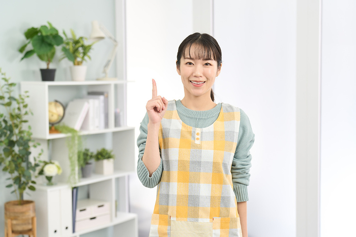 Japanese woman in apron smiling and pointing (People)