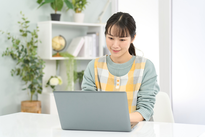 Japanese woman in apron working on computer (People)