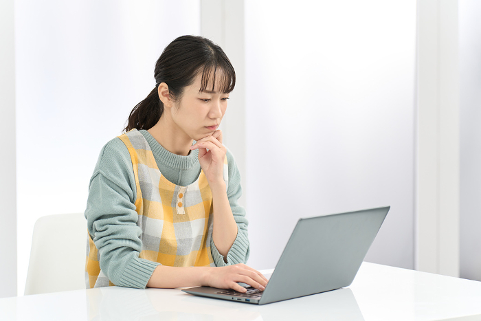 Japanese woman in apron having trouble working on computer (People)
