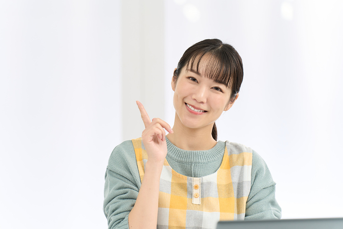 Japanese woman in apron coming up with good ideas for computer work (People)