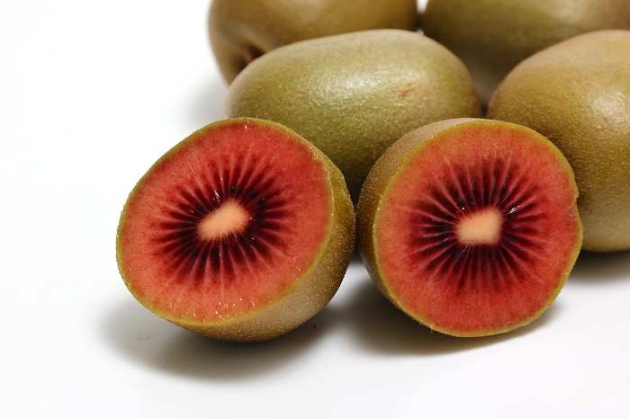Red kiwifruit with berries on white background