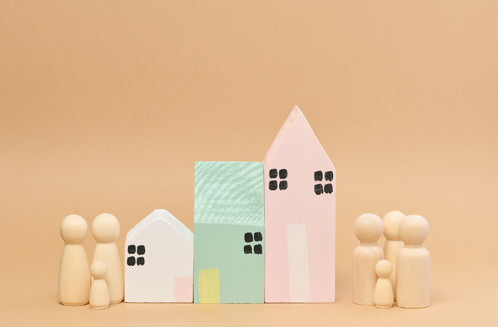 Wooden houses and wooden men of a family with children. Concept of searching for rental housing, mortgage Wooden houses and wooden men of a family with children. Concept of searching for rental housing, mortgage