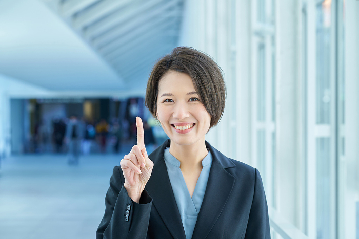 Japanese woman posing with index finger raised (People)