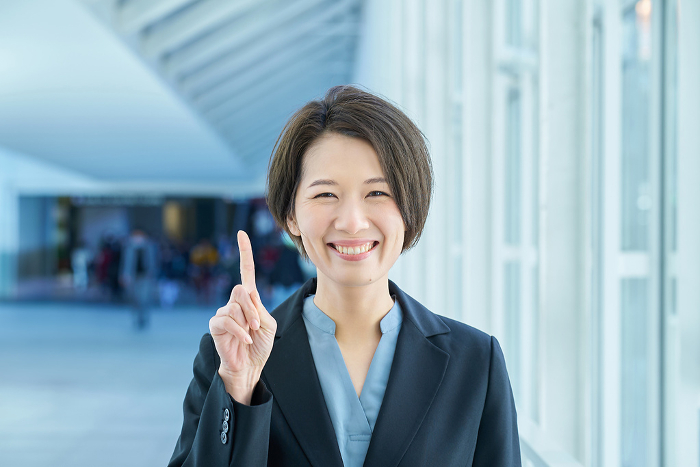 Japanese woman posing with index finger raised (People)