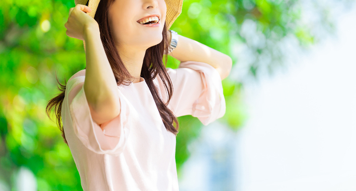Smiling Japanese woman wearing a straw hat, summer heat stroke prevention (People)