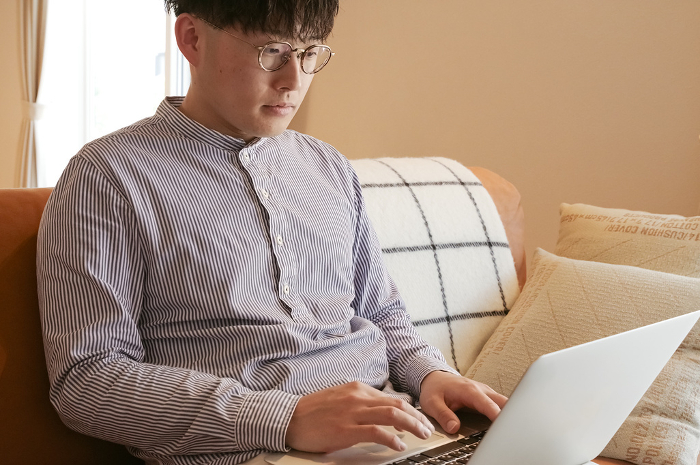 Young man using computer in living room