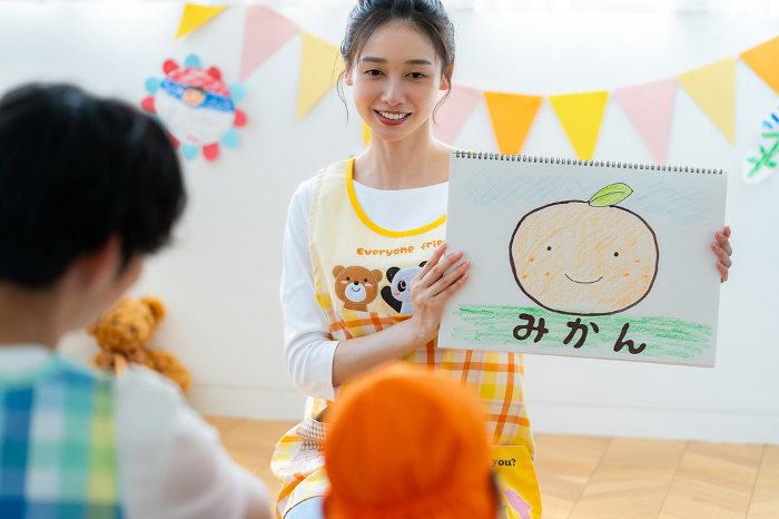 Japanese nursery school teacher performing a picture-story show (Female / People)