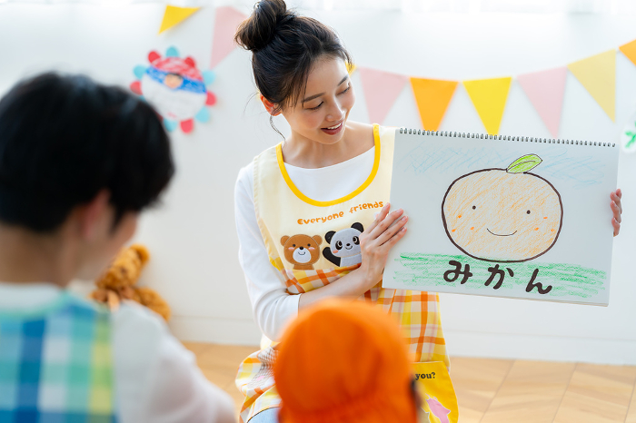 Japanese nursery school teacher performing a picture-story show (Female / People)