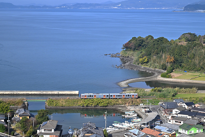 Series YC1 diesel train running on an embankment near a fishing port on the Omura Line, Nagasaki Prefecture Taken at Senben Station   Matsubara Station